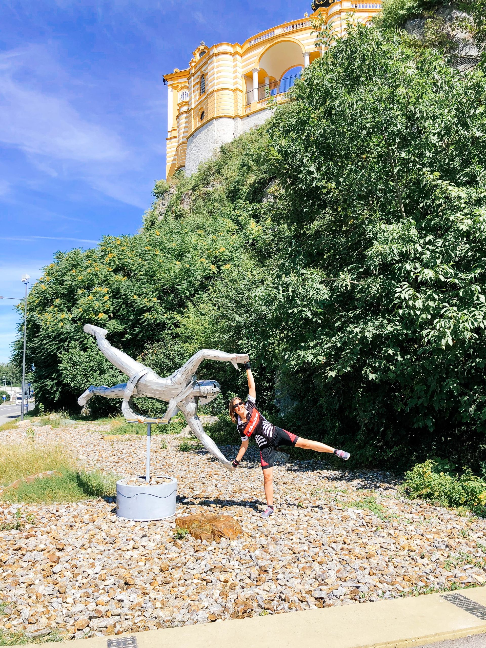 Ciclista vicino a una statua di Cavaliere sulla piazza principale di Grein, piccolo borgo lungo il Danubio.